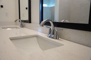 A bathroom sink with a chrome faucet and quartz countertops at West Row Lofts and Townhomes in Birmingham, AL